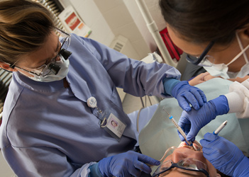 A 新葡京博彩 student performing dental work on a patient