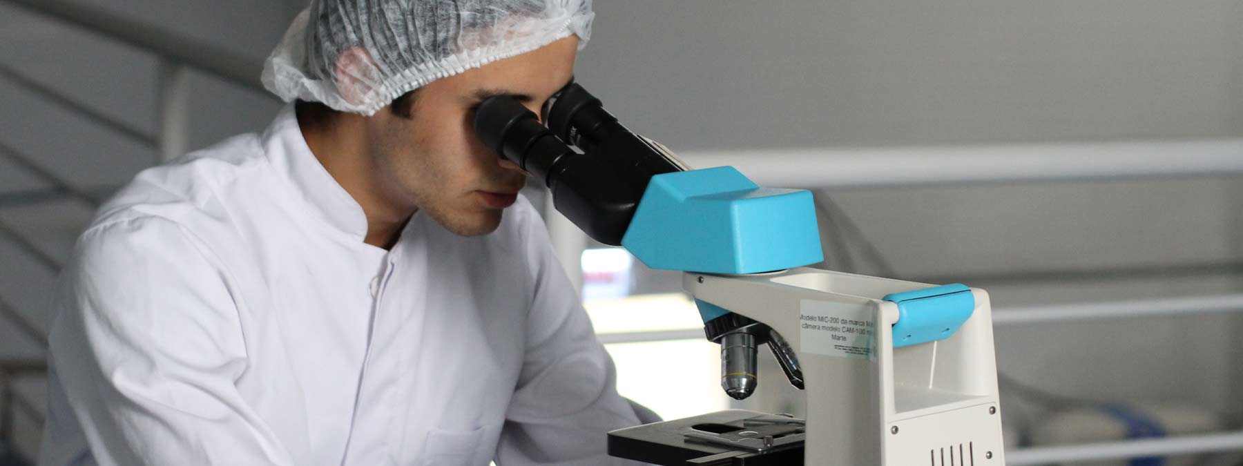 public health professional looking at specimen through a microscope